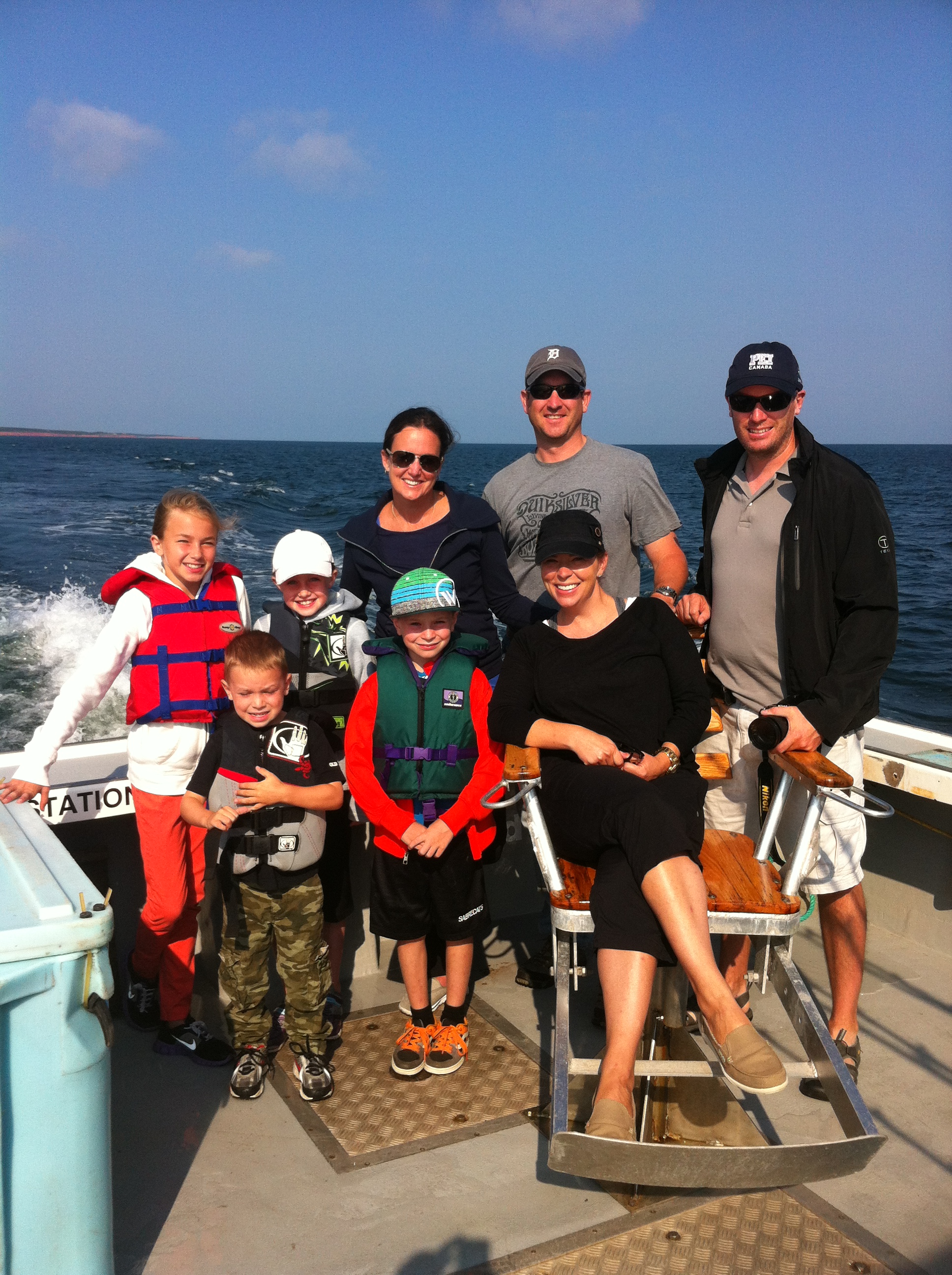 Family on deep sea charter fishing tour sitting around chair